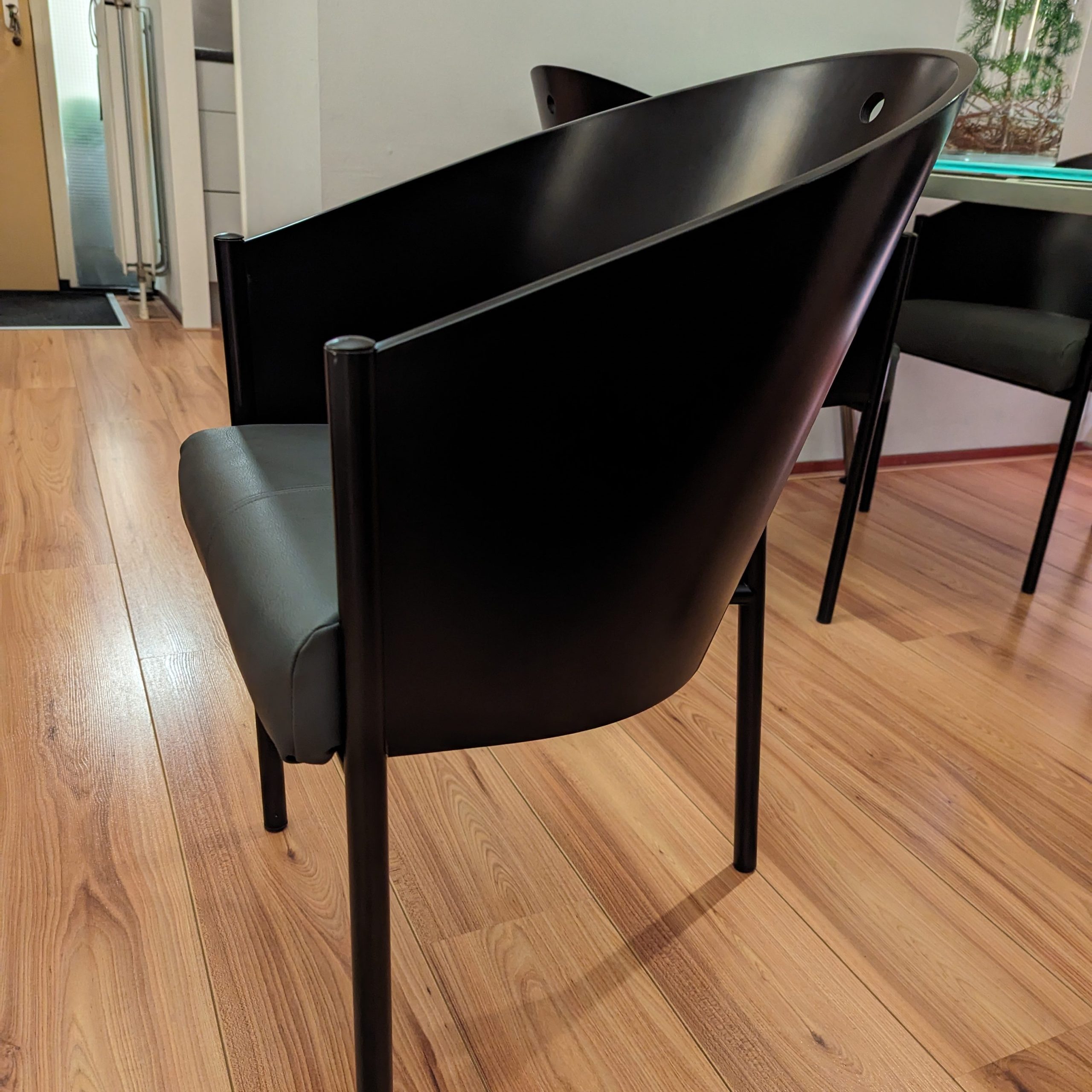 4x Driade ‘Costes’ Chairs by Philippe Starck: “Set of four Driade ‘Costes’ chairs designed by Philippe Starck, featuring a curved wooden backrest and a black metal frame, embodying modern elegance.”