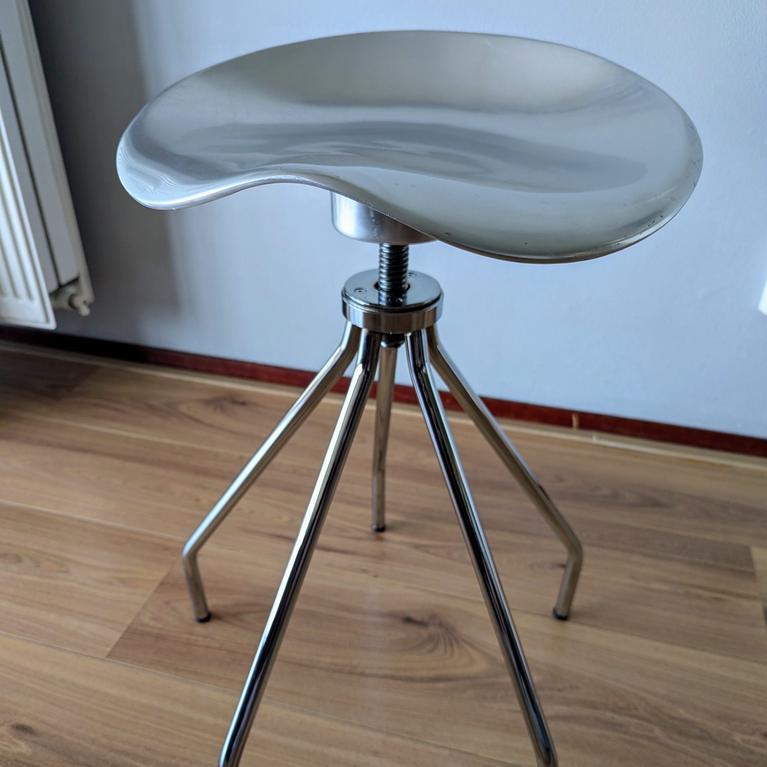 Amat ‘Jamaica Low’ Stool by Pepe Cortés: “Amat Jamaica Low stool designed by Pepe Cortés, featuring a polished aluminum seat with a distinctive curved design on a sturdy base.”